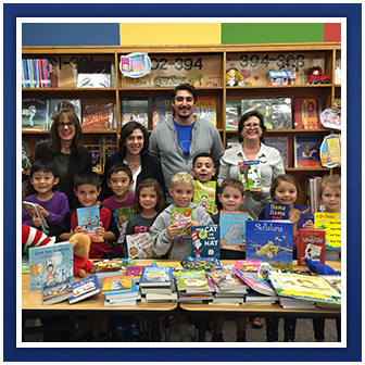 Students and teachers pose with books in a library