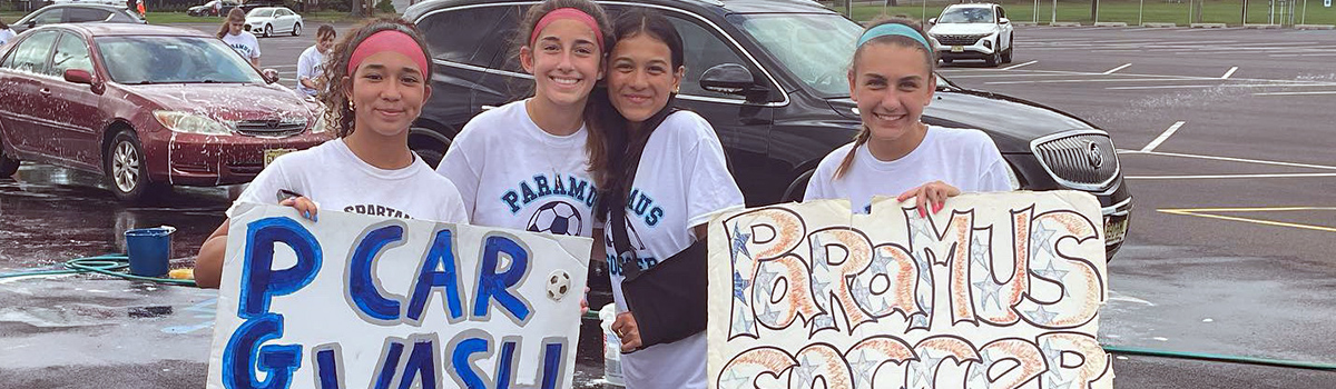 Female students students having fun hosting a car wash