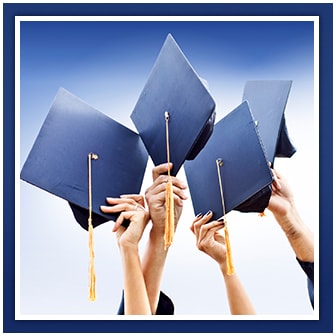 Graduates hold up their mortar boards with tassels