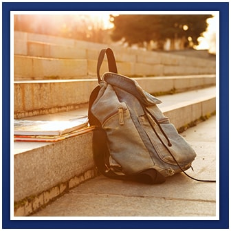 Backpack and notebooks sit on outdoor steps