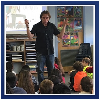 Adult speaks to students in a classroom