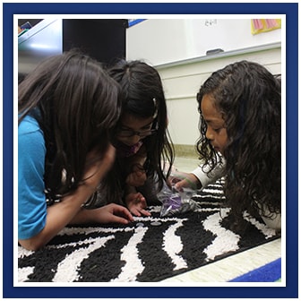 Three students use money in a class activity