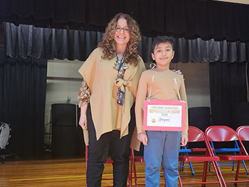Ridge Ranch spelling bee champion Divyam Gajera with a staff member