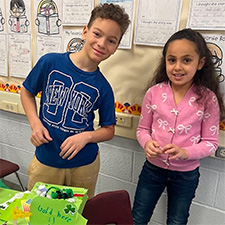 Two students behind a table with leprechaun traps