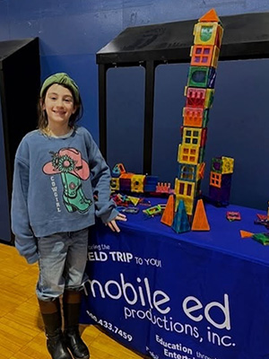 Student next to a tower of colored blocks