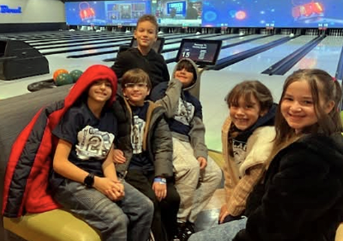 Group of students on the bowling alley smiling for the camera
