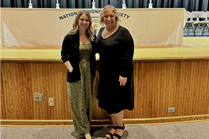 A student and an adult standing in front of the stage