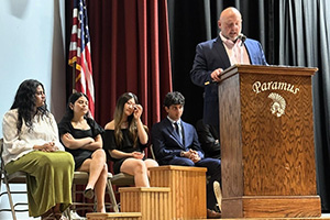 Four students sitting behind a man talking