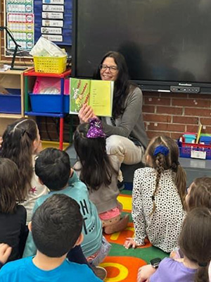 Teacher showing book illustration to class