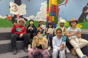 students holding up items from a Dr. Seuss book