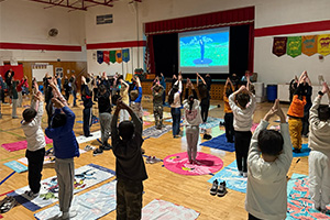students standing with their hands above their heads