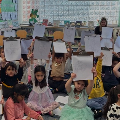 Students holding their drawings