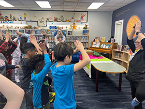 Janet Wong doing hand motions with students