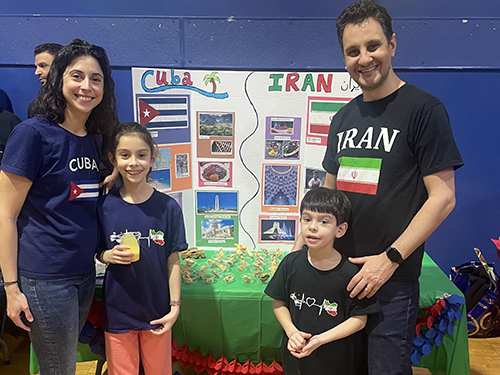Family enjoying the Cuba and Iran table displays at the festival